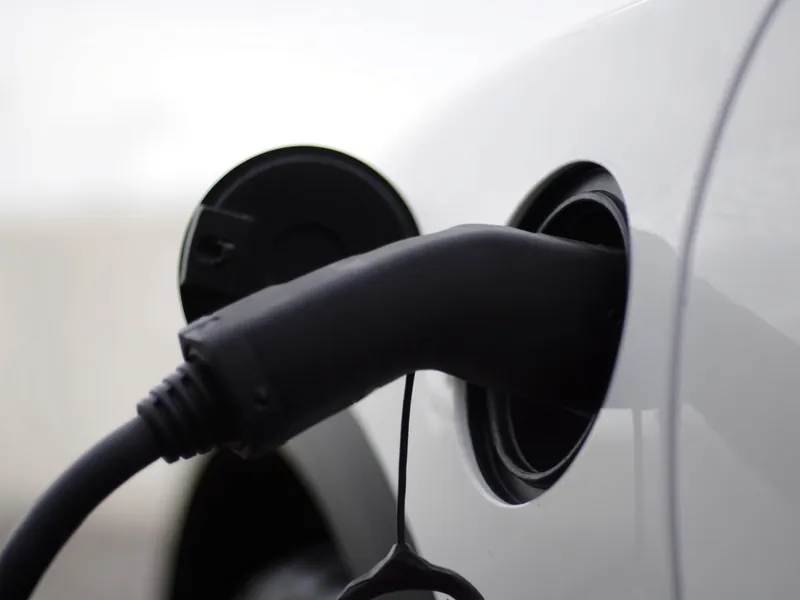 Nahaufnahme eines Ladesteckers in einem weißen Elektroauto